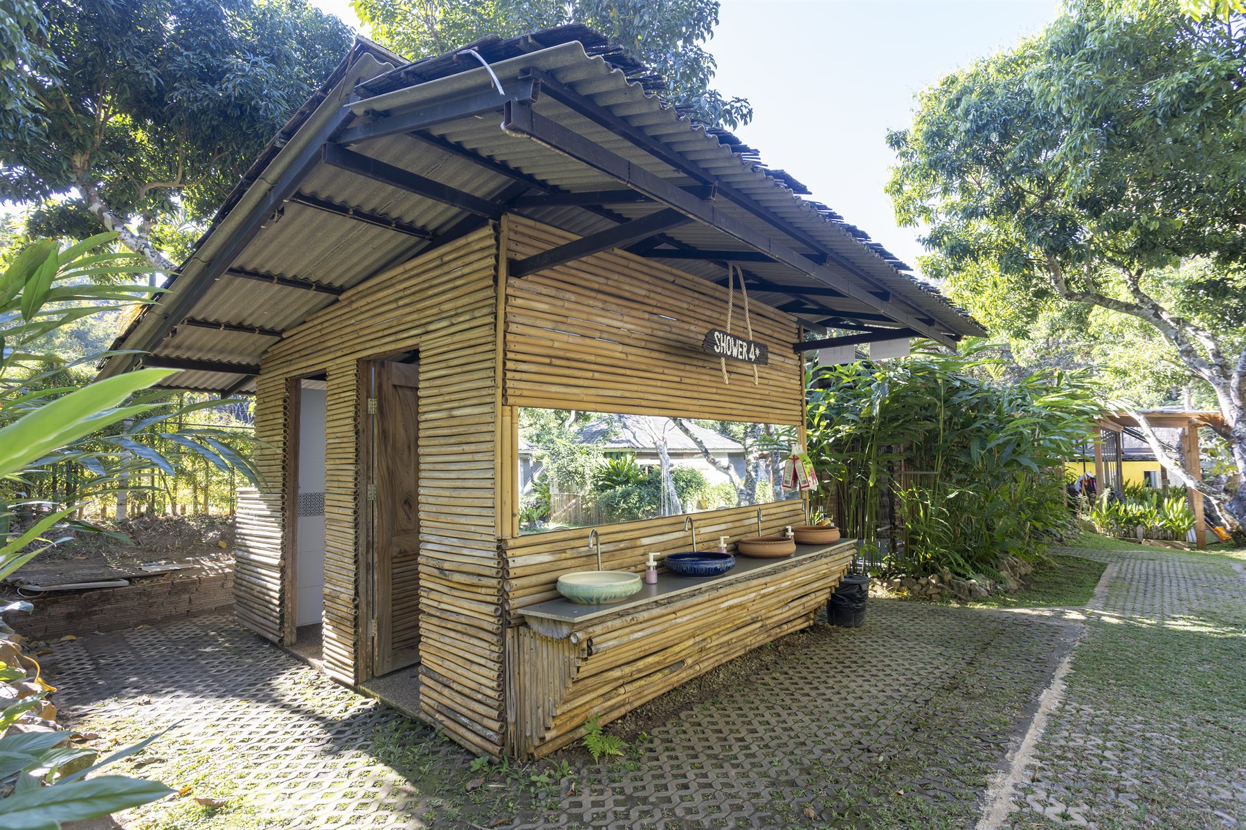 Open-air bamboo shower rooms at the Tubing Chiang Mai base camp