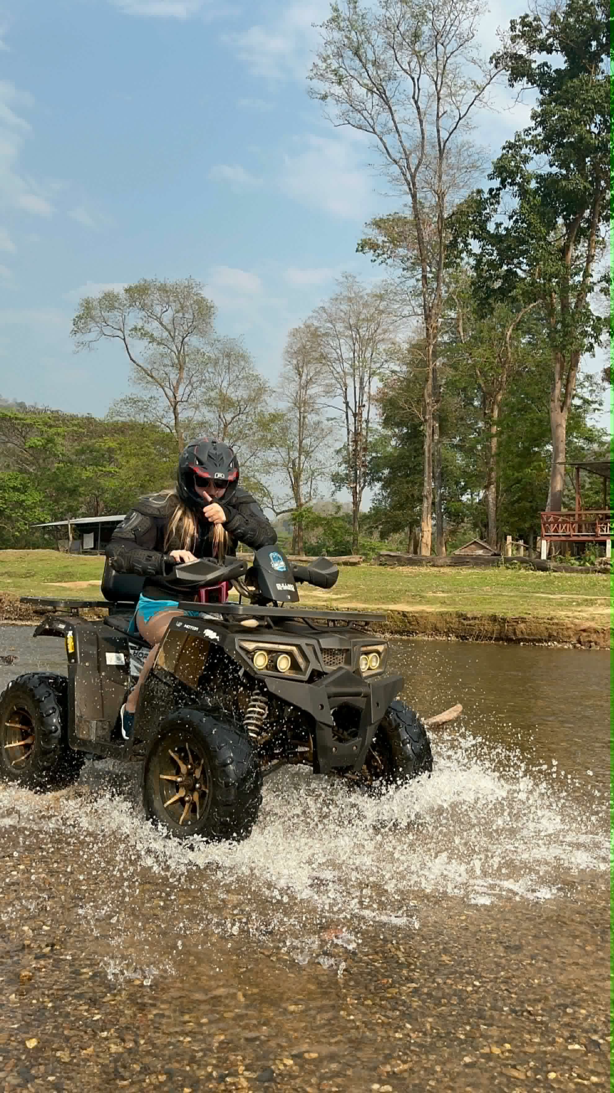 Guest crossing the river on an ATV with a thumbs up
