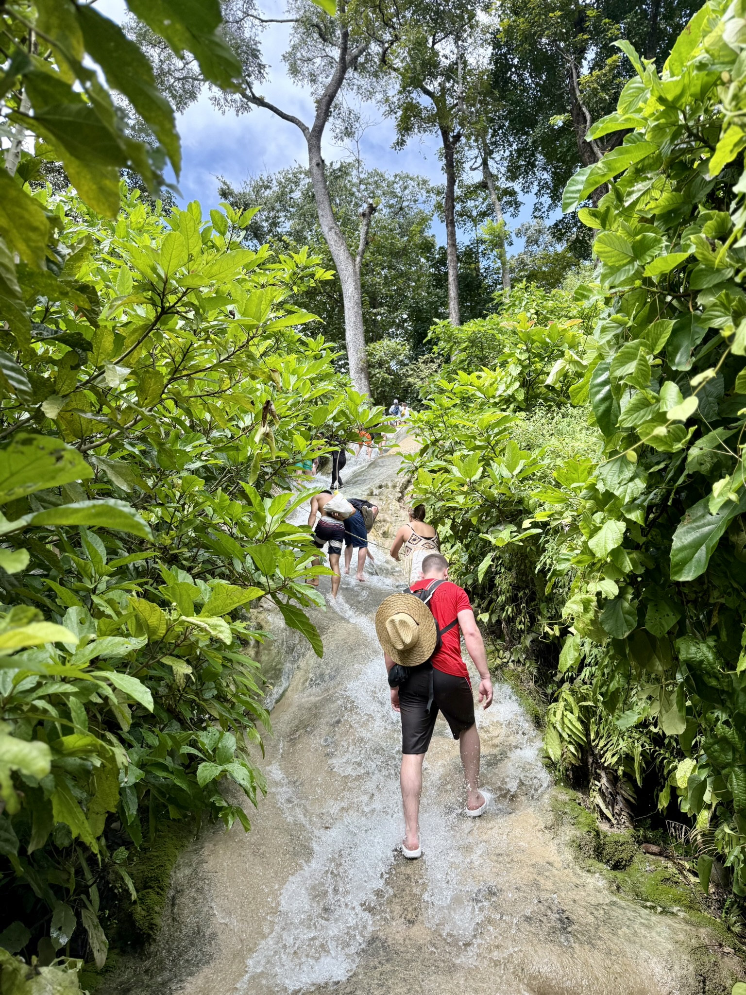 Walking barefoot up the flowing limestone of Bua Tong Sticky Waterfall through the jungle