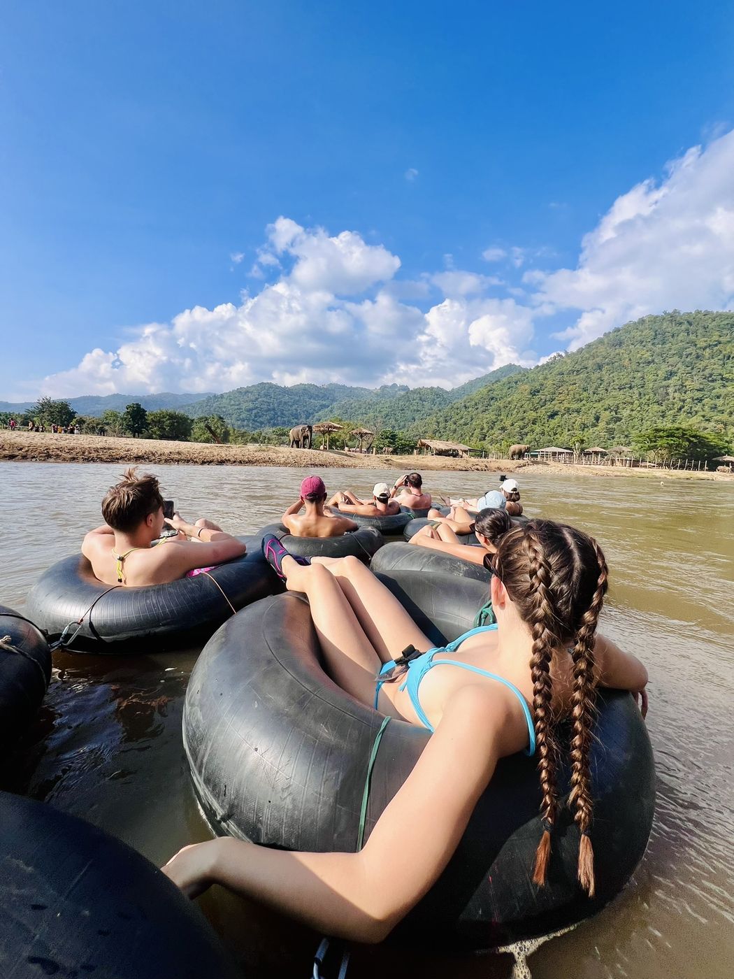 A traveller relaxing in her tube as the group drifts ahead of her down the river