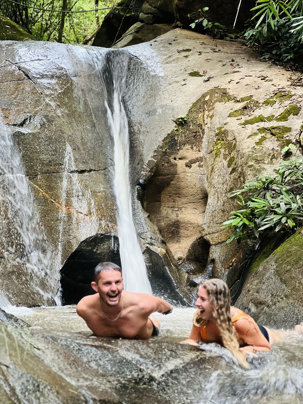 Two guests cooling off under the jungle waterfall slide